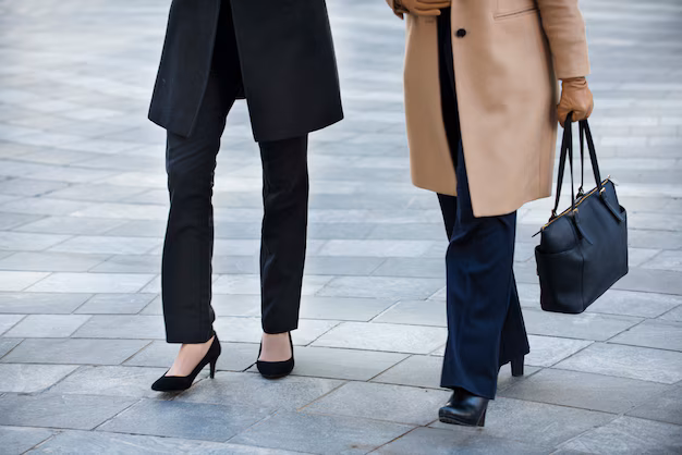 Zwei Frauen mit Mänteln und einer Aktentasche